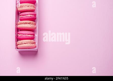 Colorful sweet macarons or macaroons, flavored cookies in the paper box. Top view. Stock Photo