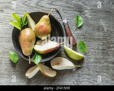 Ripe pears on plate on the wooden table in the garden. Top view. Stock Photo