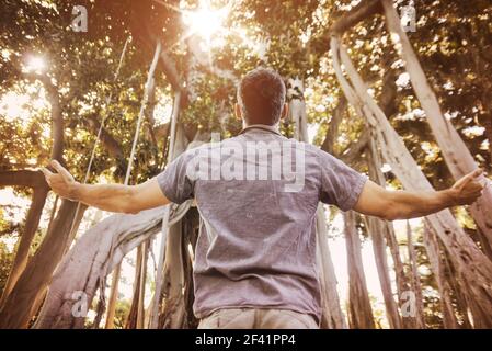 Relaxed guy enjoying summer time in a tropical forest Stock Photo