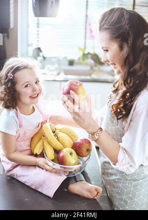Cheerful family in the kitchen - fruit diet theme Stock Photo