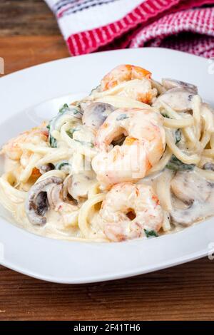 creamy keto alfredo shrimp and mushroom pasta with spinaches with palm heart noodle Stock Photo