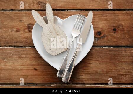 Easter table overhead view with a rabbit shape on a plate with cutlery Stock Photo