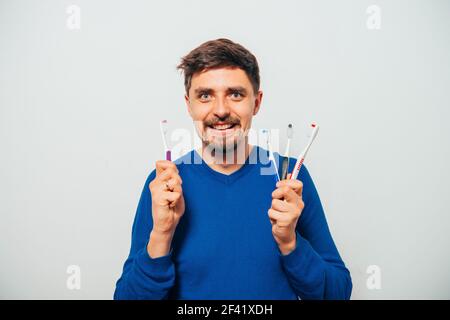man holding toothbrushes Stock Photo