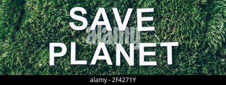 Inscription Save planet on moss, green grass background. Top view. Copy space. Banner. Biophilia concept. Nature backdrop Stock Photo