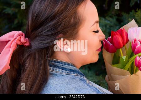 Woman with a pink bow in her hair holding tulip bouquet Stock Photo