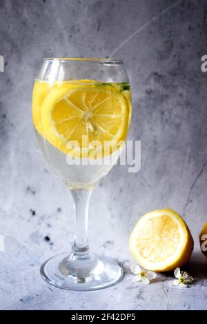 Lemons and a glass of lemonade on a gray background Stock Photo