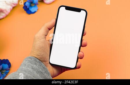 Man using smartphone mockup with blank white screen, flat lay workspace design concept Stock Photo