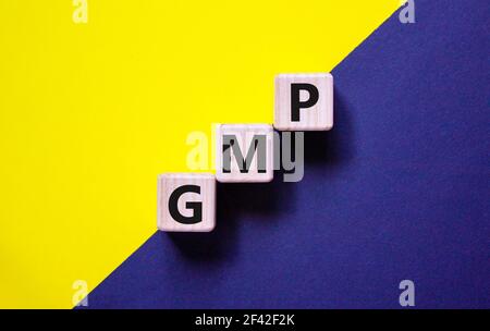 GMP, good manufacturing practice symbol. Concept words 'GMP, good manufacturing practice' on cubes on a beautiful yellow and black background. Busines Stock Photo