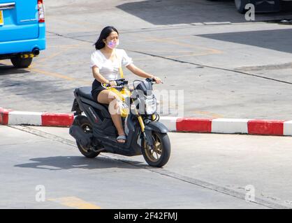 SAMUT PRAKAN, THAILAND, JUNE 26 2020, A woman with face mask rides a motorcycle Stock Photo