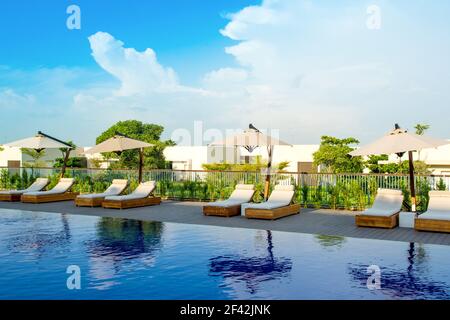 Ajman, United Arab Emirates - 30 October 2018: Pool area with sunbeds and umbrellas in a luxury hotel in Al Zorah coastline Stock Photo
