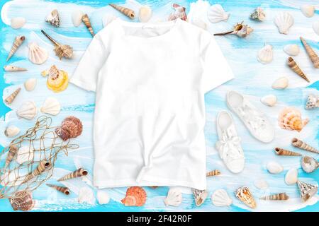 T-shirt mockup flat lay. Sea shells on blue wooden background Stock Photo