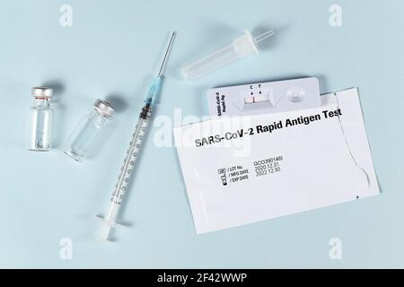 Tools to fight Corona Virus pandemic including rapid antigen test and vaccine vials with syringe Stock Photo