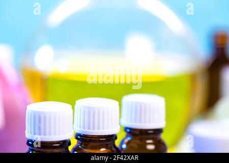 A set of flasks with chemical reagents on the background of a large glass flask with a yellow solution in a real laboratory. Chemical laboratory with Stock Photo