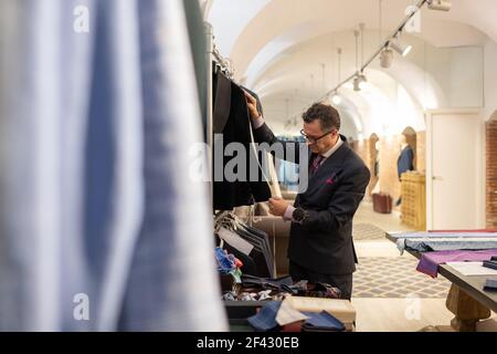 Senior man measuring jacket with tape in studio Stock Photo