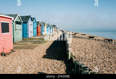 colourful huts on a pebble beach on a sunny day in England