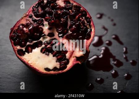 High Angle View of Red Pomegranate Cross Section on Black Background Stock Photo