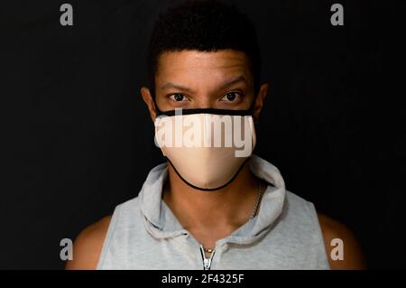 Young latin man with face mask and defiant look Stock Photo