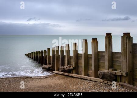 Wooden groynes on Eastbourne beach in Sussex, England, on a cloudy winter afternoon Stock Photo