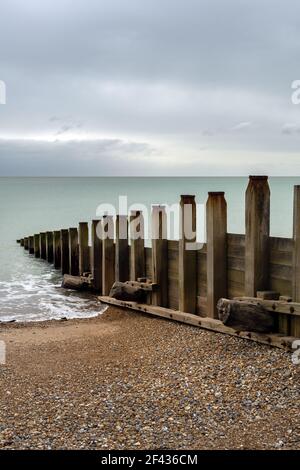 Wooden groynes on Eastbourne beach in Sussex, England, on a cloudy winter afternoon Stock Photo