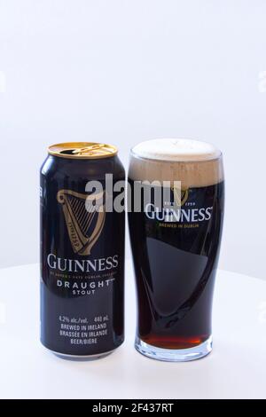 Calgary, Alberta, Canada. March 12, 2021. A Can of Guinness with a Pint of Beer draught on a white background. Stock Photo