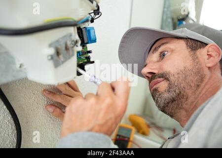 male plumber working on central heating boiler Stock Photo