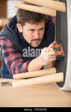 artisan using spirit level to check chair base Stock Photo