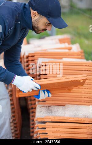 bricklayer industrial worker installing brick masonry Stock Photo