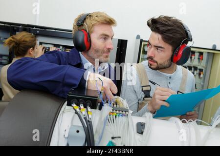 two young engineers working with electronics details Stock Photo