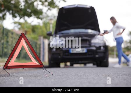 woman after placing emergency warning triangle sign Stock Photo