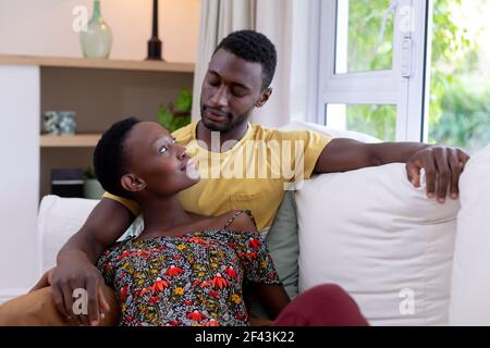 African american couple sitting on sofa embracing Stock Photo