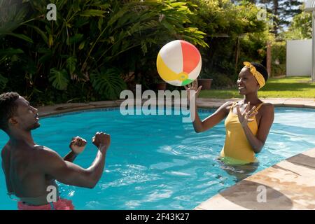 African american couple playing in swimming pool on sunny garden terrace Stock Photo