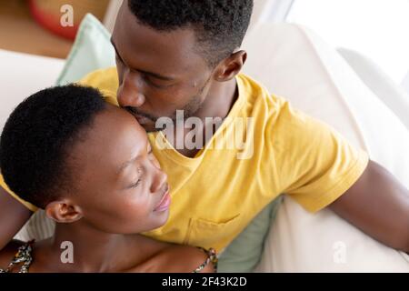 African american couple sitting on sofa embracing Stock Photo