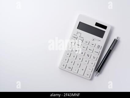 A calculator and pen on a white background. Business image Stock Photo