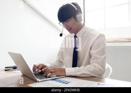 young confident male call center operator customer service representative doing his job on the phone with headset Stock Photo