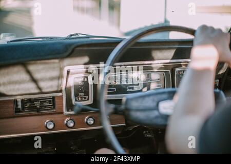 Driving ford valiant golden hour with arm across steering wheel classic vintage car dashboard Stock Photo