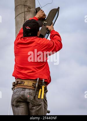 Workman attaches LED lgiht to pole for festival Stock Photo