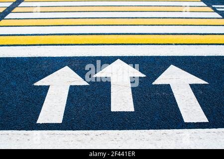 Yellow and white pedestrian crossing marking on the road. Urban photography. Sign. Directional arrows painted on a crosswalk. Pedestrian crossing. High quality photo Stock Photo