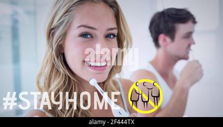 Illustration of social distancing sign and stay home text over smiling woman brushing teeth Stock Photo