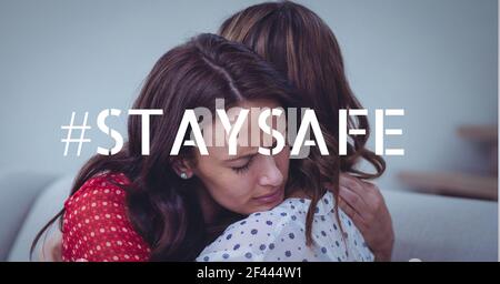 Stay safe text over mother hugging her daughter Stock Photo