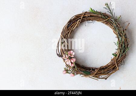 Decorative spring wreath made of twigs and flowers. DIY creativity. Selective focus. Stock Photo