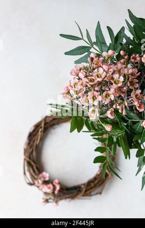 Decorative spring wreath made of twigs and flowers. DIY creativity. Selective focus. Stock Photo