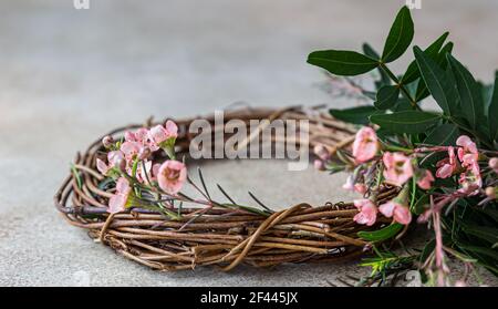 Decorative spring wreath made of twigs and flowers. DIY creativity. Selective focus. Stock Photo