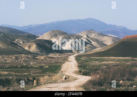 Dirt road leading to the mountains Stock Photo