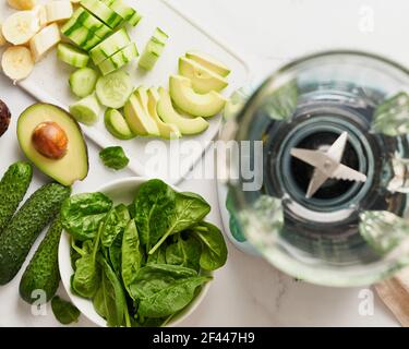 Top view mixture ingredients with fruits and vegetables on table and empty blender.  Stock Photo
