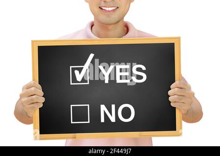YES NO check boxes on blackboard held by smiling man - survey & evaluation concept Stock Photo