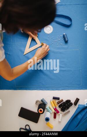Focused designer working with blue cloth at atelier Stock Photo