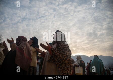 Kashmiri Muslim devotees raise hands while beseeching for blessings as the head priest (not framed) displays relic believed to be from beard of Prophet Muhammad during the celebration.Devotees from across Kashmir thronged the revered Hazratbal shrine for congregational prayers and to have a glimpse of the holy relic of Islamic Prophet Muhammad on the occasion following of Meraj-ul-Alam (ascension to heaven) in Srinagar. Stock Photo