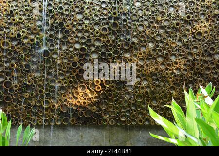 Abstract artificial waterfall or water cascade wall made from bamboo stalks Stock Photo