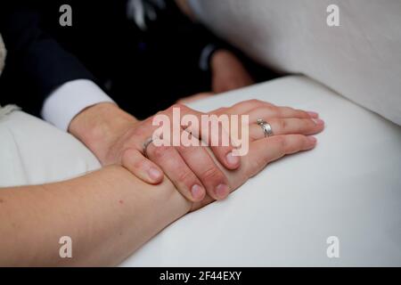 A closeup shot of a newlywed couple holding hands Stock Photo