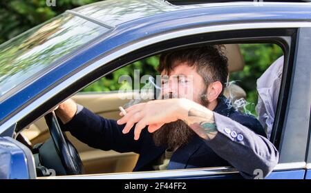 Driver smoking cigarette. Minute to relax. Businessman tired after hard negotiations smoking vehicle. Man bearded businessman smoking cigarette while Stock Photo